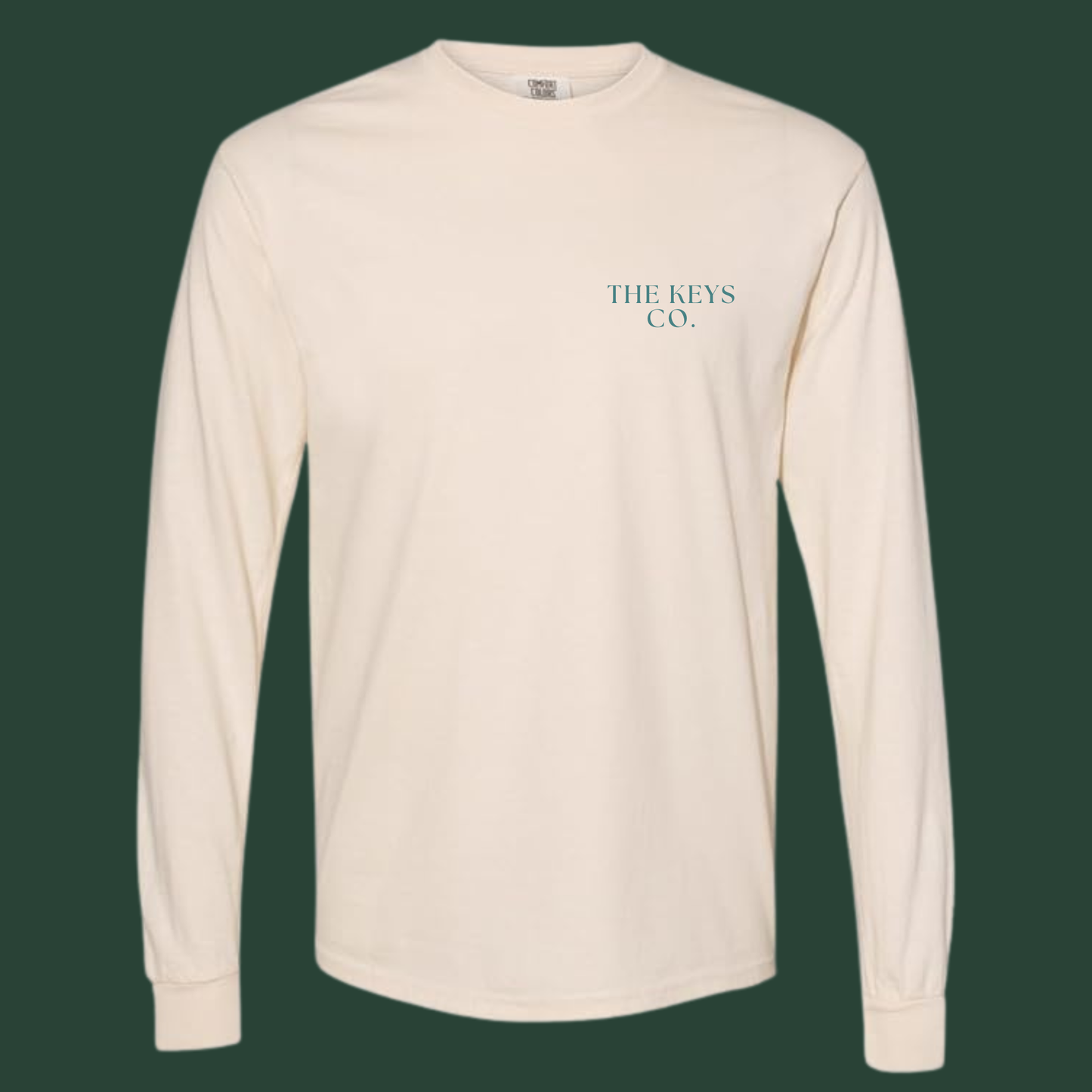 Beige long-sleeve shirt with 'THE KEYS CO.' logo on a dark green background